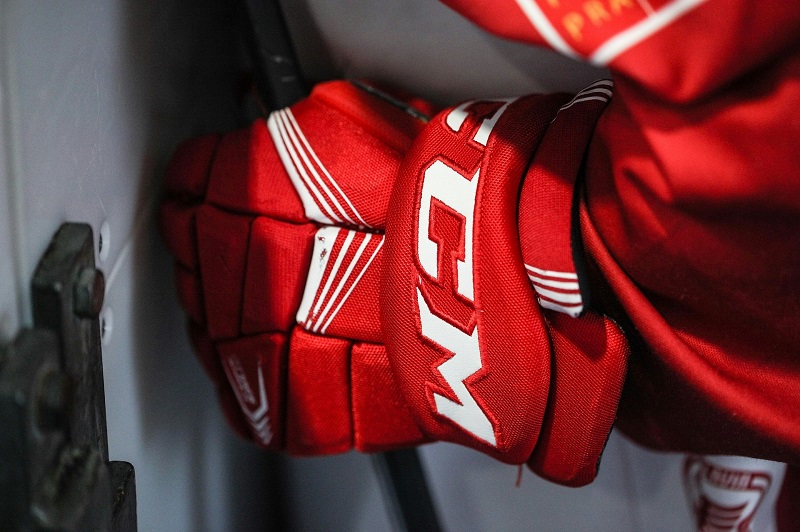 the player wears red ice hockey gloves