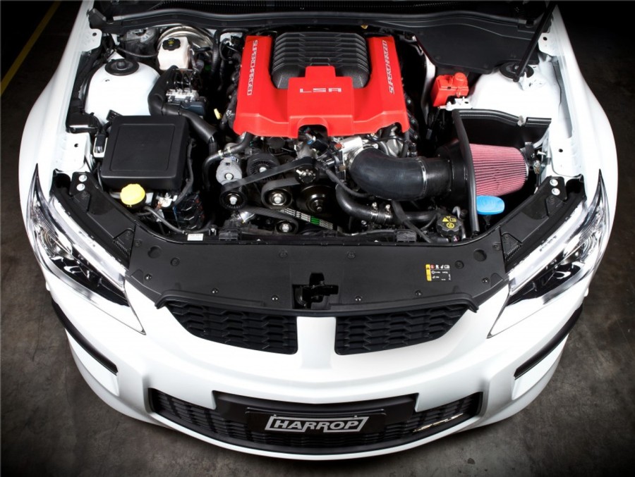 Detailed view of a Harrop performance air intake system with red cover on a supercharged car engine